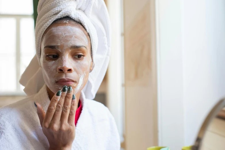 a woman with a towel on her head shaving her face, a portrait, trending on pexels, portrait of ororo munroe, partially cupping her hands, manuka, early evening