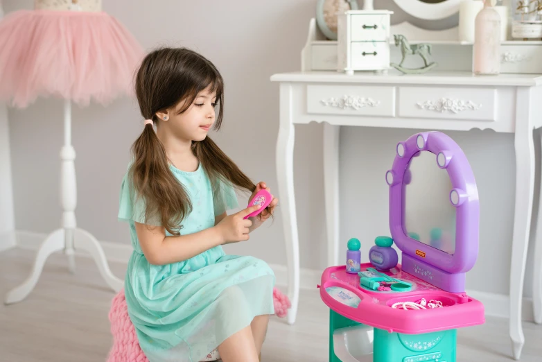 a little girl sitting on a stool in front of a vanity, mauve and cyan, playing games, argos, with a mirror