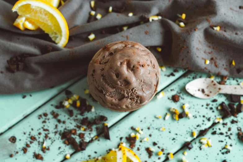 a chocolate ice cream sitting on top of a table, lemon, background image, spherical, shot on sony a 7 iii