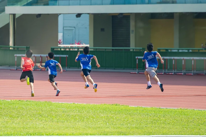 a group of young men playing a game of soccer, inspired by Baiōken Eishun, pexels contest winner, three people running a marathon, singapore, panorama shot, school