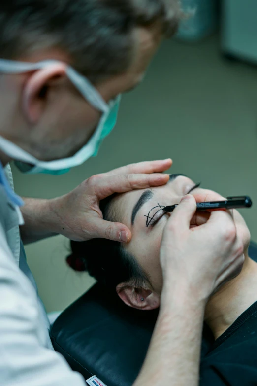 a man getting his eyebrows done by a dentist, by Adam Marczyński, pexels contest winner, hurufiyya, dark eyeliner, marina abramovic, surgical gear, with professional makeup