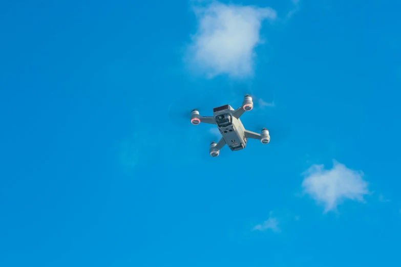 a white drone flying through a blue sky, unsplash, square, flying toasters in heaven, vehicle, birdeye