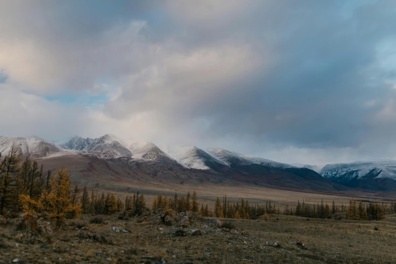 the mountains are covered in snow on a cloudy day, a portrait, unsplash contest winner, ancient mongolian elon musk, autumn, 4k), music video