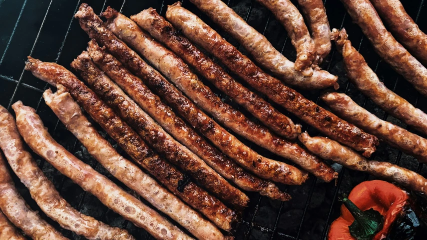 a bunch of sausages sitting on top of a grill, trending on pexels, hurufiyya, sichuan, thumbnail, greek, crackles