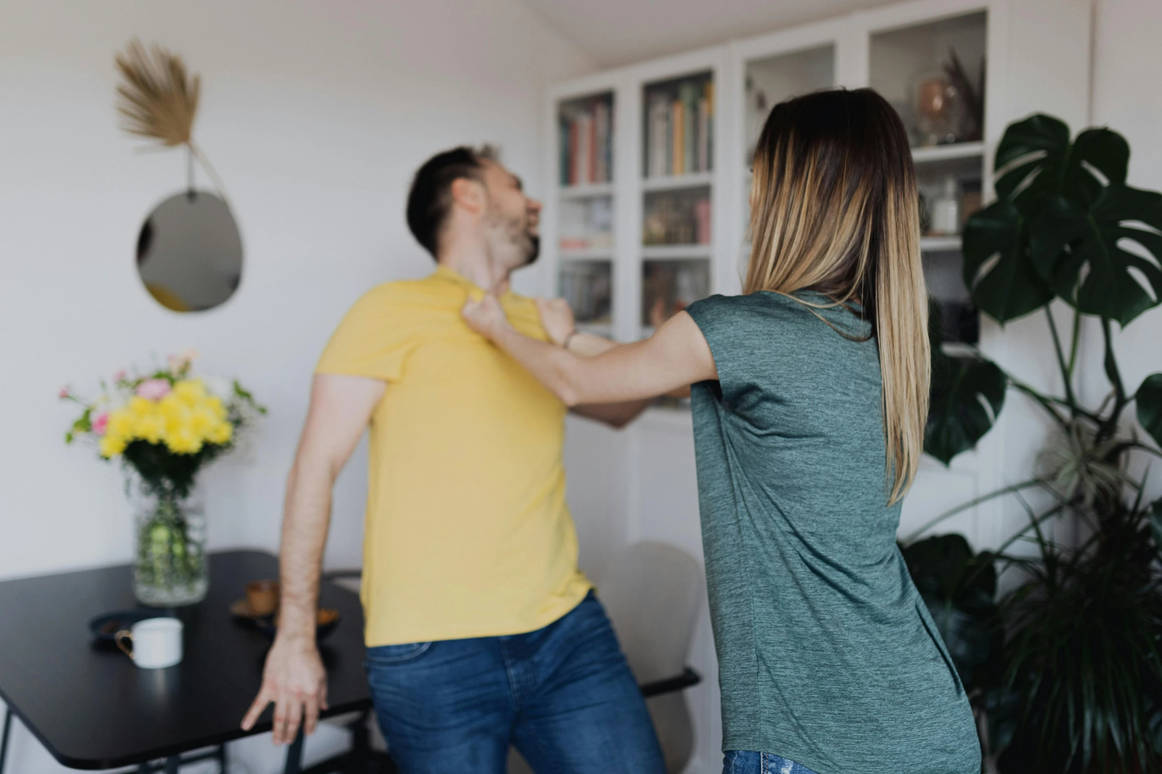 a man standing next to a woman in a living room, pexels contest winner, punching, his back is turned, profile image, manuka