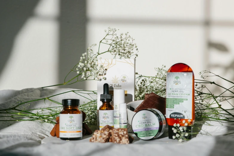 a variety of skin care products sitting on a table, inspired by Eden Box, unsplash, hemp, “ iron bark, set against a white background, herbs and flowers