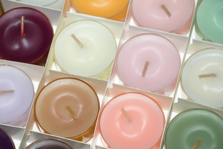 a box filled with lots of different colored candles, by Nina Hamnett, plasticien, muted and pastel shades, round format, panels, warm coloured