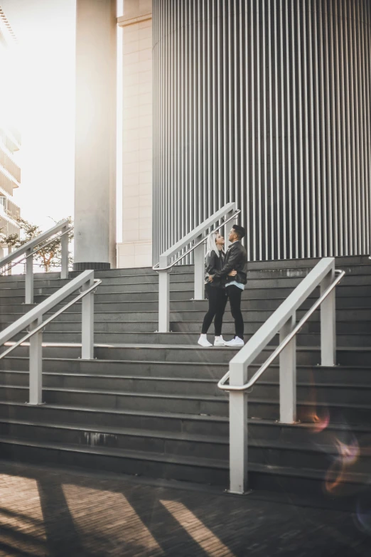 a man riding a skateboard down a flight of stairs, unsplash, happening, man and woman walking together, twins, non-binary, professional photo