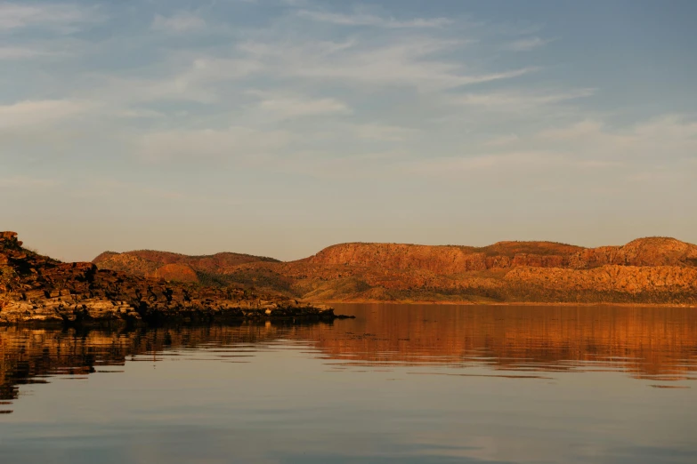 a large body of water with mountains in the background, a portrait, hurufiyya, “ iron bark, golden hour photograph, panoramic, afar