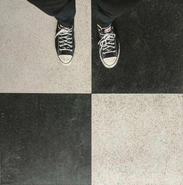 a person standing on a black and white checkered floor, an album cover, by Brice Marden, trending on unsplash, real human feet, ying and yang, 15081959 21121991 01012000 4k, square shapes