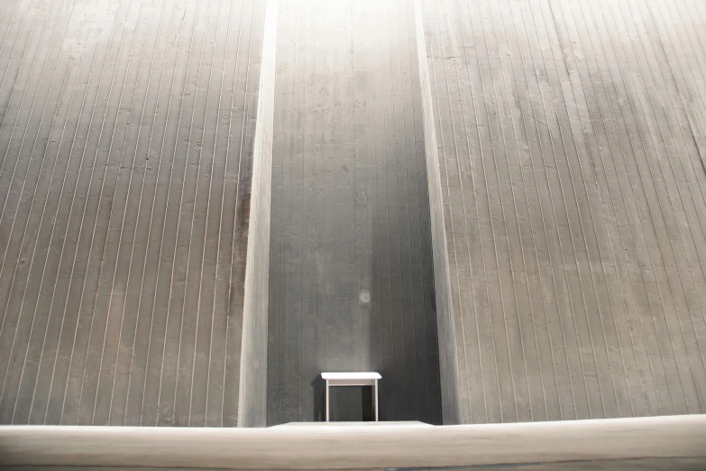 a man riding a skateboard up the side of a ramp, inspired by Tadao Ando, unsplash, brutalism, water reservoir, grey, vents, aluminum