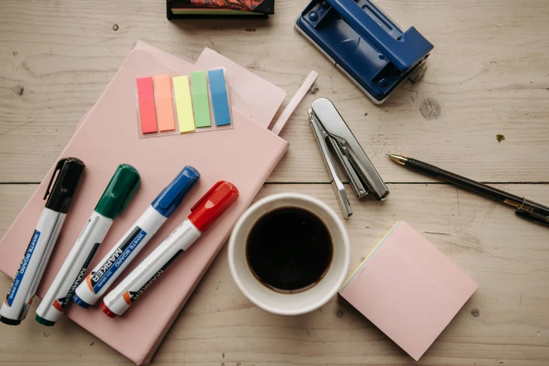 a cup of coffee sitting on top of a wooden table, educational supplies, markers, thumbnail, leaked image