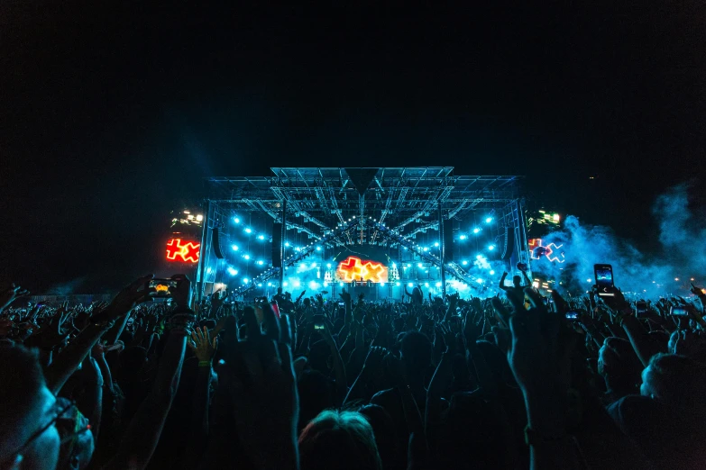 a group of people that are standing in front of a stage, pexels contest winner, dance trance edm festival, neon light showing injuries, bright sky, evenly lit