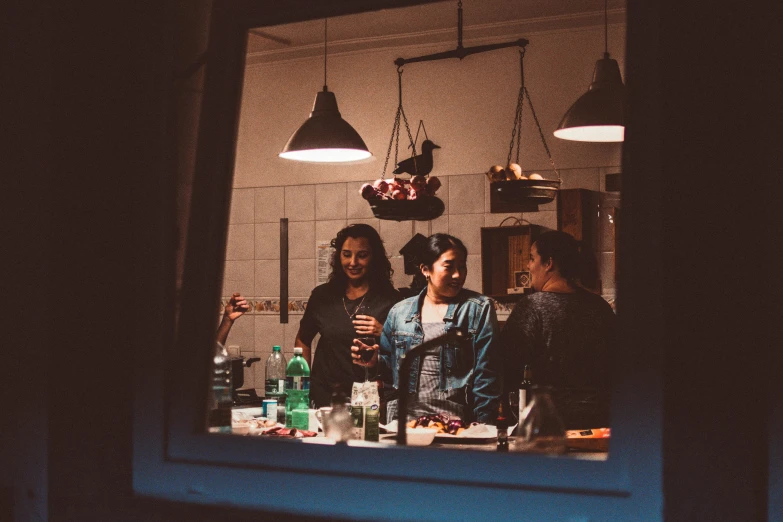 a group of people standing around a kitchen counter, pexels contest winner, evening ambience, al fresco, pitch black room, camaraderie