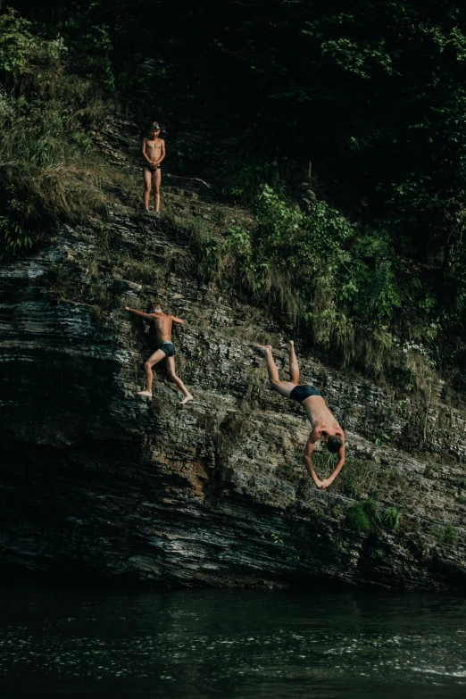 a group of people jumping off a cliff into a body of water, sri lanka, alessio albi, in the hillside, swimming