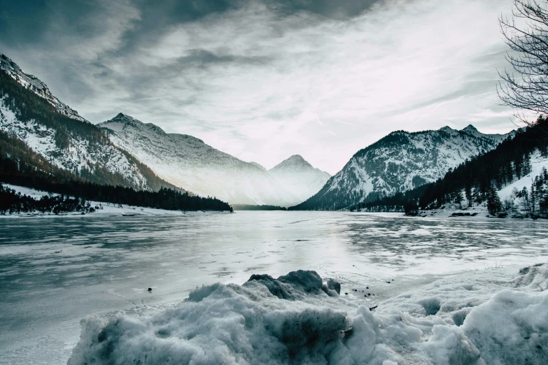 a large body of water surrounded by snow covered mountains, pexels contest winner, fan favorite, frozen, lpoty, grey