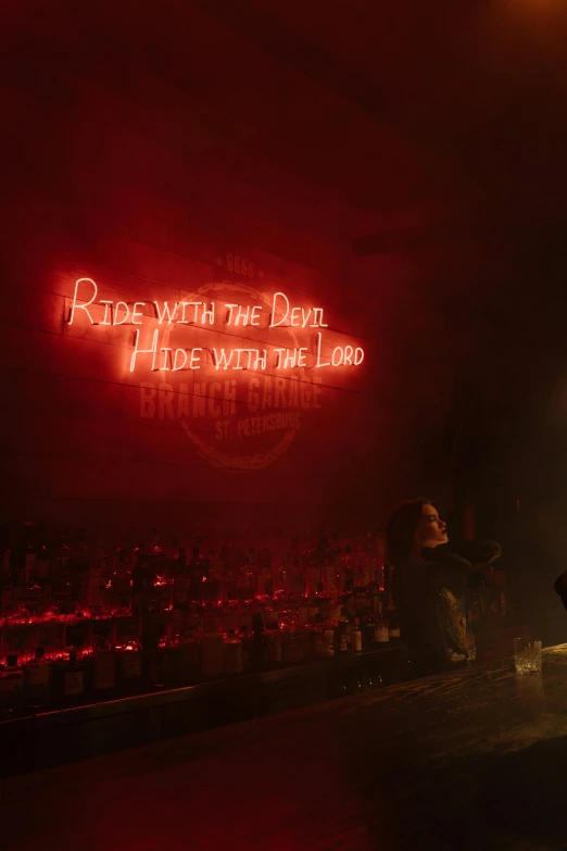 a man standing on a stage in front of a neon sign, pexels, dada, satan in hell, cozy dark 1920s speakeasy bar, rides, lighting her with a rim light