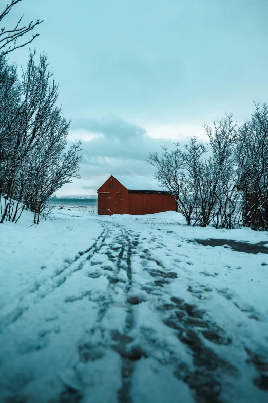 a red barn sitting on top of a snow covered field, by Jesper Knudsen, pexels contest winner, reykjavik, country road, color image, today\'s featured photograph 4k