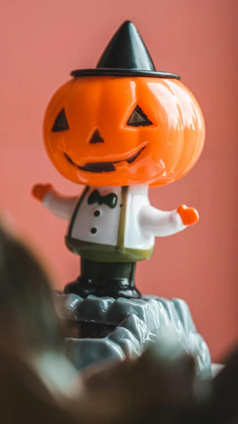 a close up of a figurine of a pumpkin, a cartoon, by Emma Andijewska, pexels, over his shoulder, retro vibe, hi-res, celebration