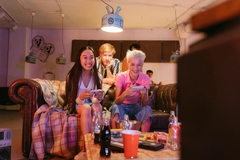 a group of people sitting on top of a couch, pexels, happening, cyberpunk teenager bedroom, tv screens in background, food, photograph of three ravers