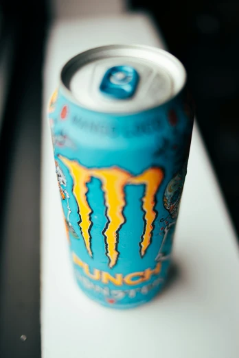 a can of monster energy sitting on a table, pexels contest winner, sucker punch, blue, close up to a skinny, noon
