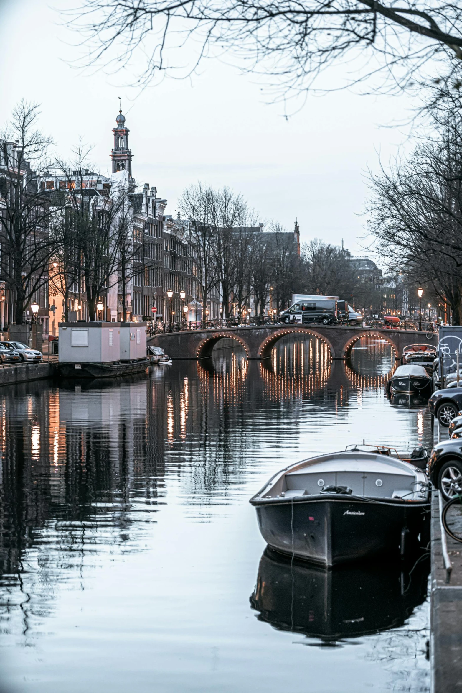 a group of boats sitting on top of a river next to a bridge, by Jan Tengnagel, pexels contest winner, neoclassicism, city light reflections, winter setting, lush surroundings, van