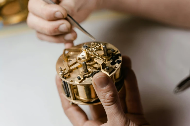 a close up of a person working on a clock, by Matthias Stom, chaumet, back towards camera, instruction, brown