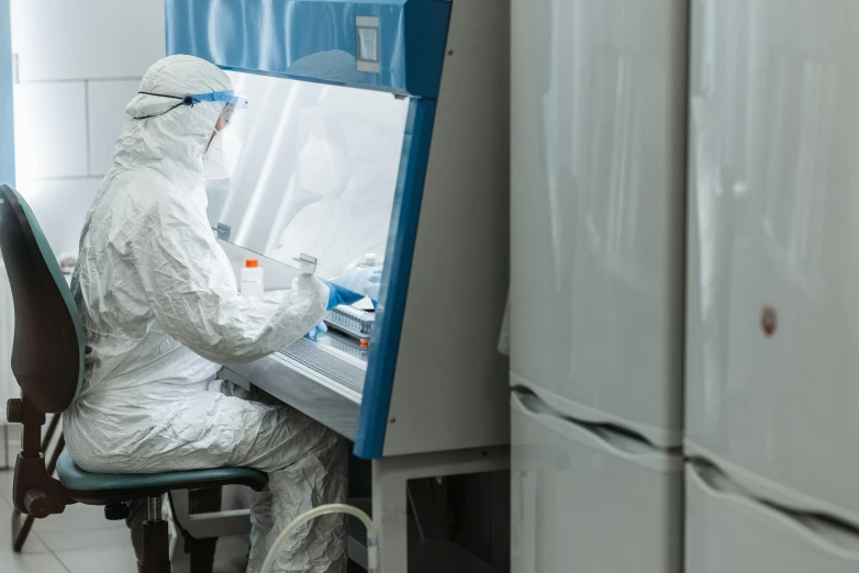 a man sitting at a desk in a lab, a picture, shutterstock, staff wearing hazmat suits, incubator medpods, thumbnail, uhq