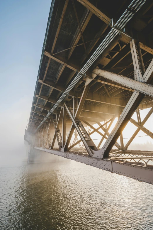 a bridge over a body of water on a foggy day, by Sven Erixson, unsplash contest winner, industrial steam, mongolia, underside, high quality photo