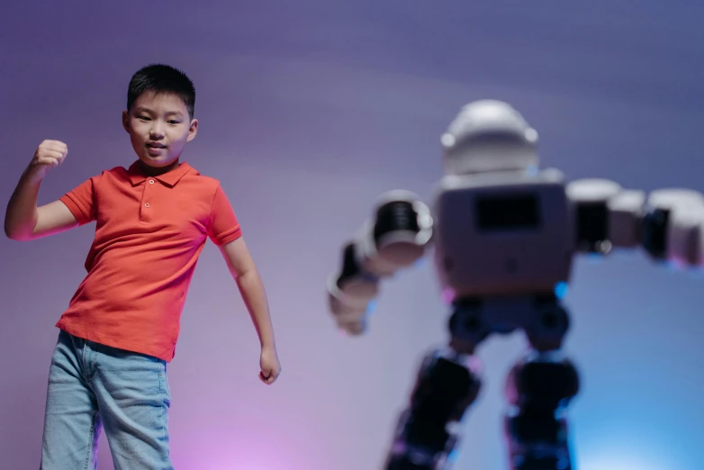 a young boy standing in front of a robot, pexels contest winner, interactive art, dancing in the background, darren quach, action pose, 15081959 21121991 01012000 4k