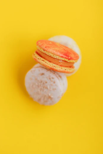 three macarons stacked on top of each other, pexels, pop art, yellow and ornage color scheme, over-shoulder shot, half moon, detailed product shot
