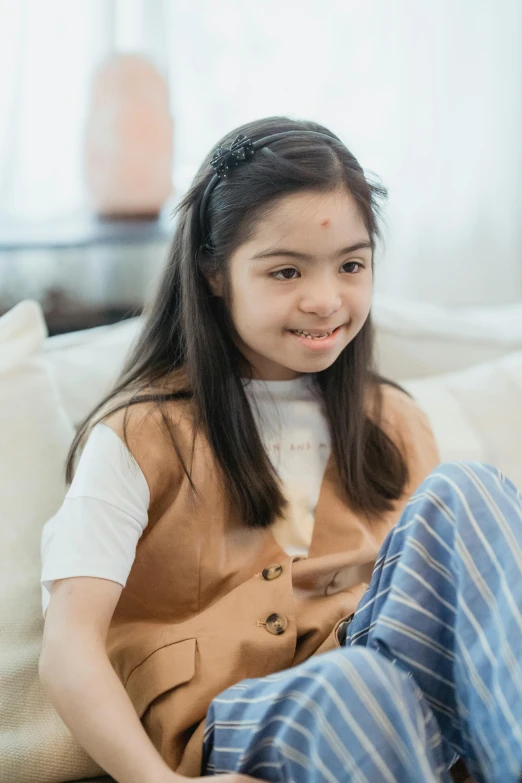 a little girl that is sitting on a couch, inspired by Nazmi Ziya Güran, pexels contest winner, smiling slightly, marfan syndrome, teenage girl, kuntilanak