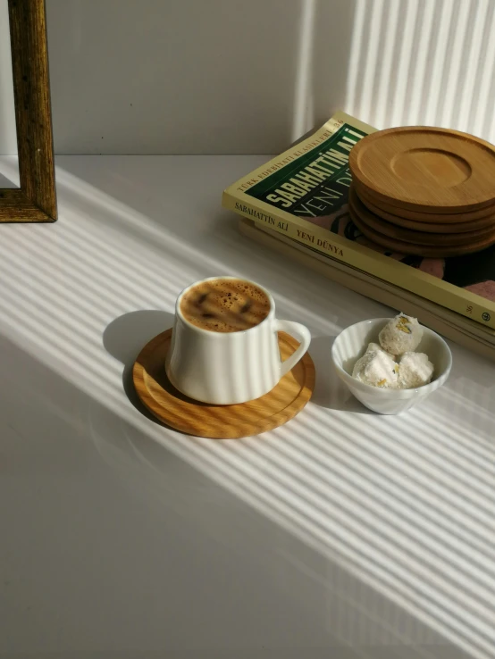 a cup of coffee sitting on top of a table, by Jang Seung-eop, light cream and white colors, brown, small, product image