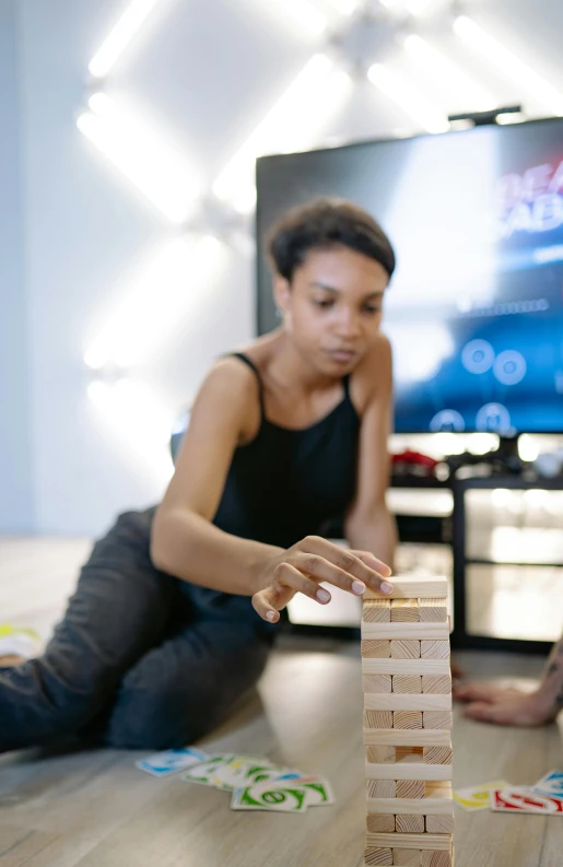 a couple of people sitting on the floor playing a game, stacked image, alexis franklin, person in foreground, blocks