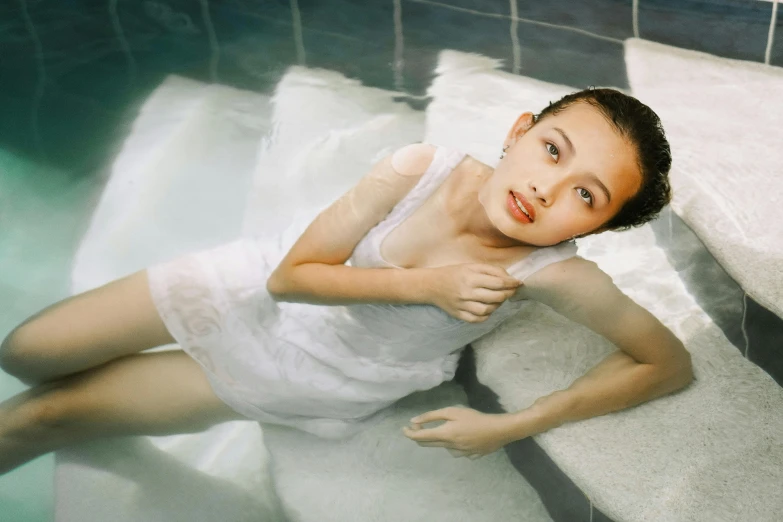 a woman in a white dress sitting in a pool, inspired by Zhang Yan, pexels contest winner, beautiful little girl, translucent skin, aged 13, 奈良美智