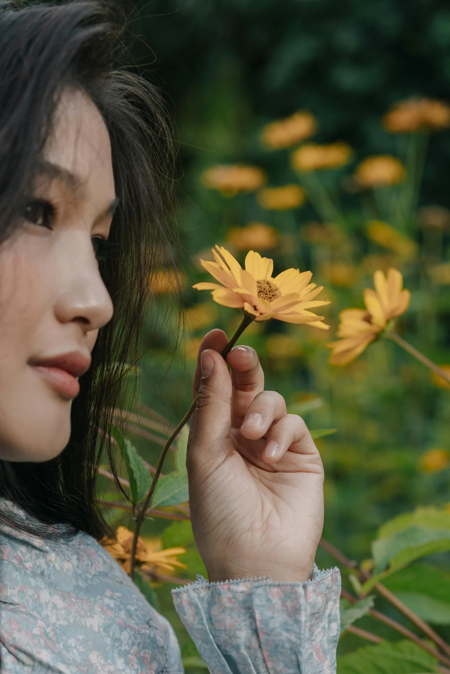 a woman holding a yellow flower in her hand, inspired by Xie Sun, trending on pexels, beautiful young himalayan woman, japanese, brown, perky woman made of petals