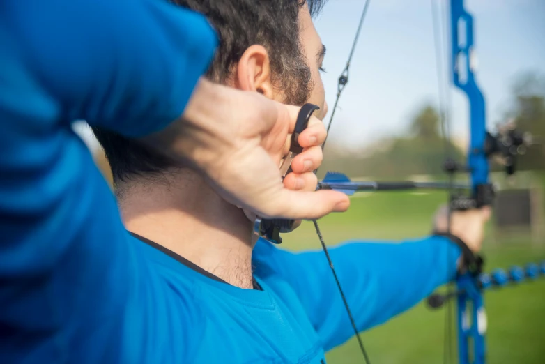 a close up of a person holding a bow and arrow, sports setting, thumbnail, head and shoulders, jamie coreth