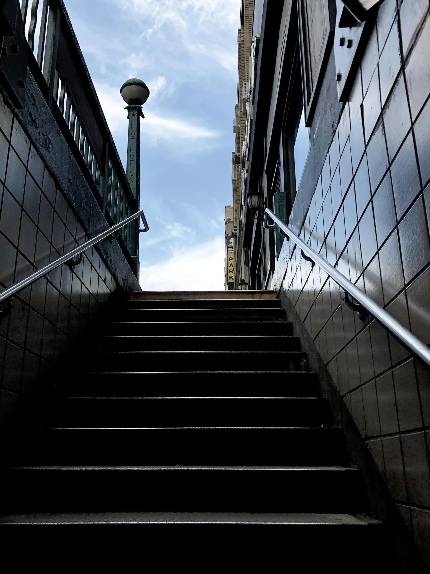 a set of stairs going up the side of a building, unsplash, non-binary, low quality photo, exiting store, looking to the sky