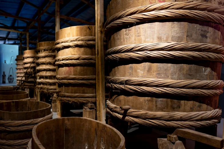 a bunch of wooden barrels stacked on top of each other, hanfu, ropes, profile image, inside a tall vetical room