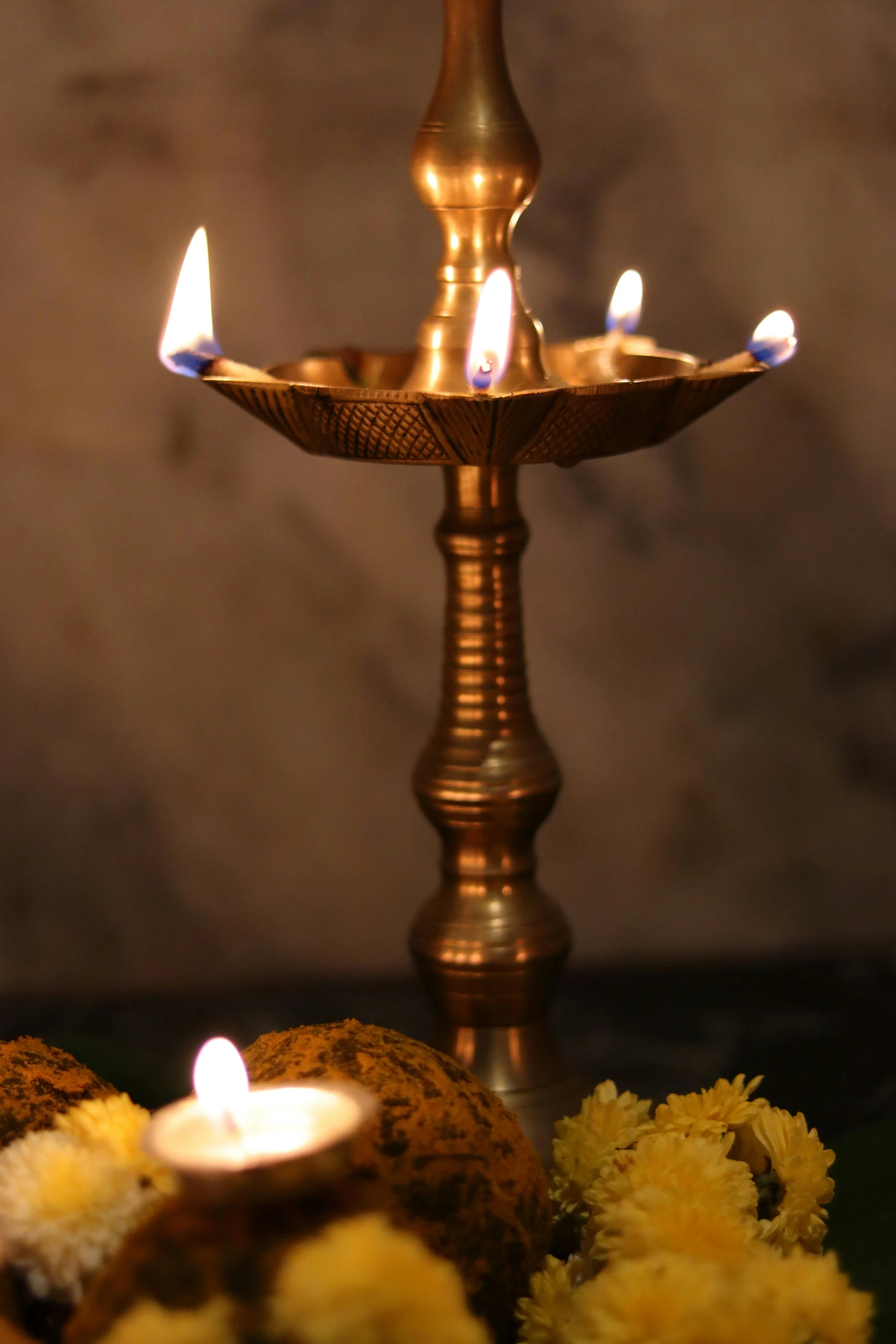 a group of candles sitting on top of a table, a still life, by Bholekar Srihari, hurufiyya, floor lamps, closeup - view, traditional medium, copper