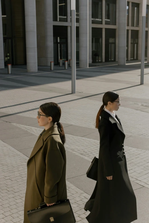 a couple of women walking down a sidewalk, inspired by Vanessa Beecroft, trending on unsplash, realism, serious business, still from the movie, berlin fashion, film still from the office