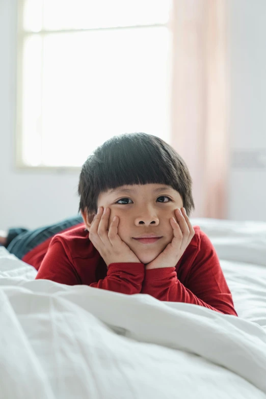 a little boy laying on top of a bed, inspired by Liang Kai, pexels contest winner, happening, looking off to the side, friendly face, lgbtq, distant thoughtful look