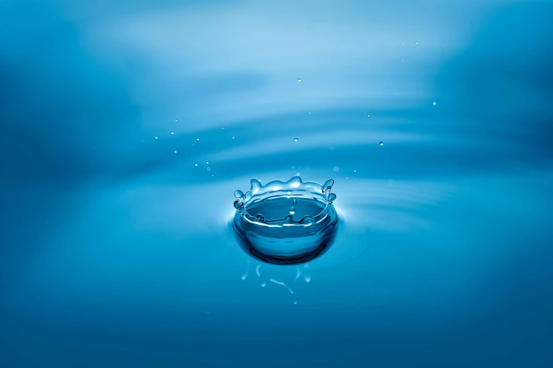 a water drop with a crown on top of it, an album cover, by Adam Marczyński, pexels contest winner, minimalism, crystal clear blue water, circular, freeform ferrofluids, blue