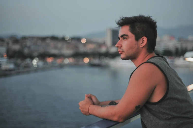 a man looking out over a body of water, pexels contest winner, happening, singer maluma, calm evening, young greek man, thoughtful )