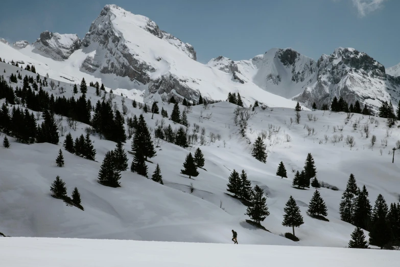 a man riding skis down a snow covered slope, by Matthias Weischer, unsplash contest winner, solo hiking in mountains trees, two mountains in background, conde nast traveler photo, sparsely populated