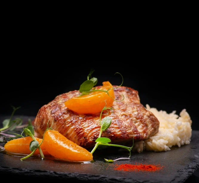 a close up of a plate of food on a table, in front of a black background, chicken, orange, food advertisement