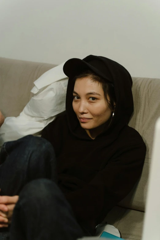 a man and a woman sitting on a couch, reddit, visual art, wearing a black hoodie, nishihara isao, she is facing the camera, bella poarch