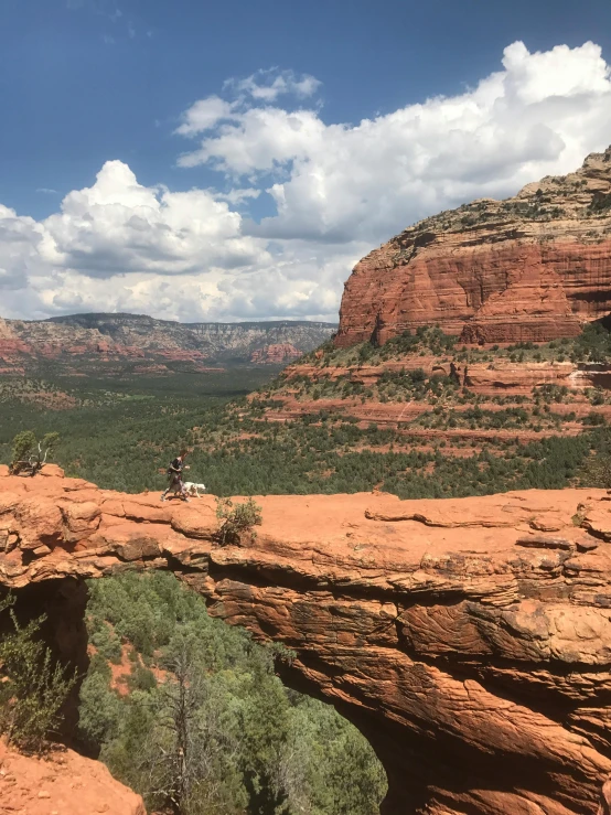 a couple of people standing on top of a cliff, sedona's cathedral rock bluff, slide show, phone photo