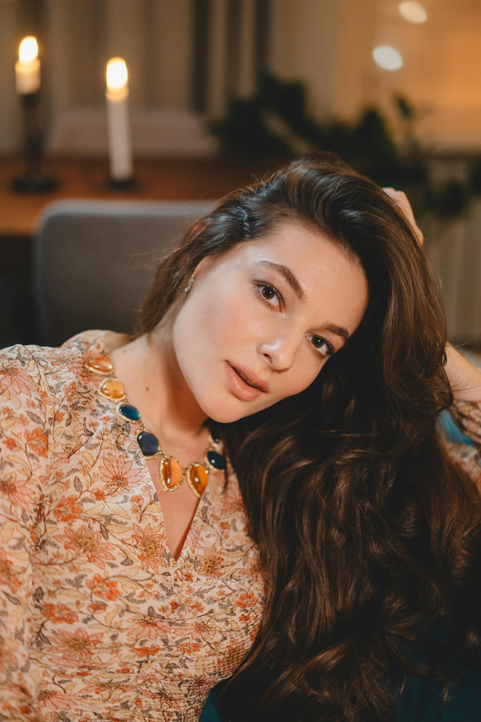 a woman sitting on a couch in a living room, inspired by Elsa Bleda, trending on pexels, renaissance, beautiful young himalayan woman, bone jewellery, headshot photo, miranda cosgrove