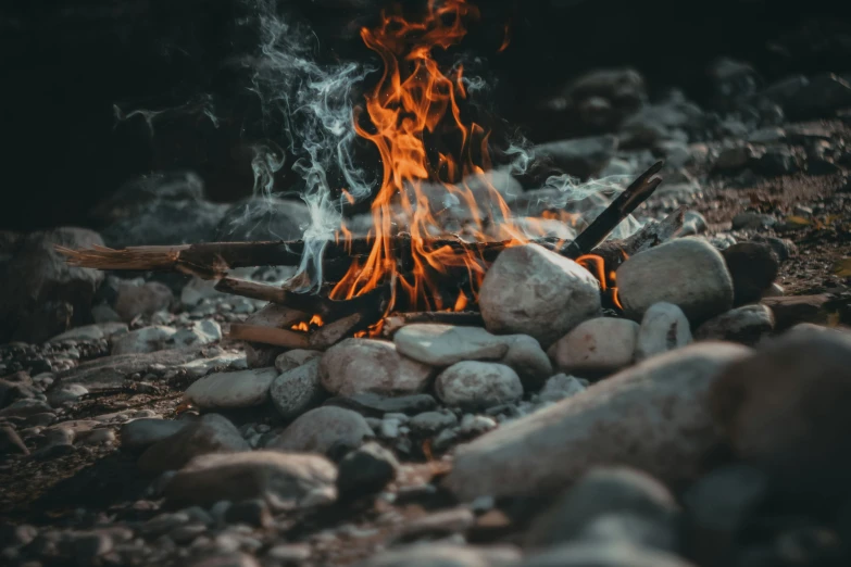 a fire sitting on top of a pile of rocks, pexels contest winner, cooking it up, avatar image, fire and water, camping